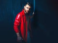 Portrait Of Young Handsome Man. Handsome man wearing red leather jacket on naked muscular torso on dark background Royalty Free Stock Photo