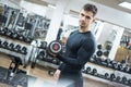 Portrait of young handsome man lifting weights in the gym. Royalty Free Stock Photo