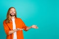 Portrait of young handsome man with long blond hair mustache demonstrating empty space ads billboard isolated on cyan Royalty Free Stock Photo