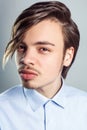 Handsome man with long fringe hairstyle on his eyes, looking at camera with mysterious look. Royalty Free Stock Photo