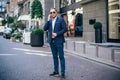 Portrait of a young handsome man, model of fashion, wearing tinted sunglasses in urban background Royalty Free Stock Photo