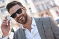 Portrait of a young handsome man, model of fashion, wearing tinted sunglasses in urban background Royalty Free Stock Photo