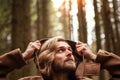 Portrait of a young handsome man, with a mysterious look, in a dark wild forest. Royalty Free Stock Photo