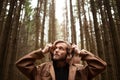 Portrait of a young handsome man, with a mysterious look, in a dark wild forest. Royalty Free Stock Photo