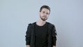 Portrait of young handsome man posing on white background,the guy is wearing a black jacket and t-shirt Royalty Free Stock Photo