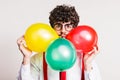 Portrait of a young man with balloons in a studio. Royalty Free Stock Photo