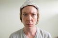 Face of young man wearing tin foil hat inside the room Royalty Free Stock Photo