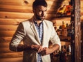 Portrait of young handsome man in white suit near home bar. Royalty Free Stock Photo