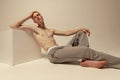 Portrait of young handsome red-haired man posing shirtless in pants isolated over grey studio background Royalty Free Stock Photo