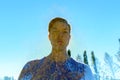 Multiple exposure of young handsome man overlaying oak tree and sun against blue sky Royalty Free Stock Photo