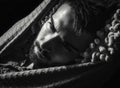 Portrait of young handsome serious man in a hammock.