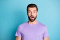 Portrait of young handsome shocked amazed surprised guy with open mouth look camera isolated on blue color background