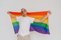 Portrait of young handsome smiling happy boy holding LGBT flag Royalty Free Stock Photo