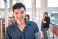 Portrait of young and handsome student smiling with friends in campus. Casual outfit of asian male in school. Royalty Free Stock Photo
