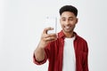 Portrait of young handsome tan-skinned american male with afro hairstyle in casual fashionable outfit smiling with teeth Royalty Free Stock Photo