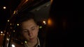 Portrait of young handsome teenager traveling in a taxi car with a driver in night city Royalty Free Stock Photo