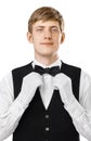 Portrait of young handsome waiter fixing his bow tie on a suit Royalty Free Stock Photo