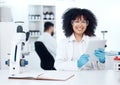Portrait of young happy african american medical scientist with an afro using a digital tablet to record test results Royalty Free Stock Photo
