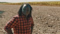 Portrait of young happy african farmer standing on the agricultural plowed land