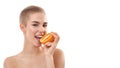 Food for healthy skin. Portrait of young and happy attractive blonde woman with short haircut eating a piece of orange