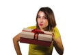 Portrait of young happy and beautiful Asian Indonesian woman giving or receiving Christmas present or birthday gift box with red Royalty Free Stock Photo