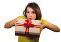 Portrait of young happy and beautiful Asian Indonesian woman giving or receiving Christmas present or birthday gift box with red Royalty Free Stock Photo