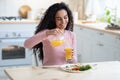 Portrait of young happy brunette lady having tasty breakfast at home Royalty Free Stock Photo