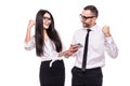 Portrait of young happy business colleagues couple isolated over white wall background using mobile phones make winner gesture Royalty Free Stock Photo