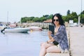 Portrait of young happy business woman relaxing, working in city, beach at Adriatic seaside. Using laptop. Selfie. Technology.