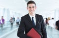 Portrait of young happy businessman in front of busy modern background.