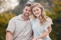 Portrait of young happy caucasian couple sitting together during a day outdoors. Handsome smiling man holding and Royalty Free Stock Photo