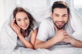 portrait of young happy couple covered with blanket looking Royalty Free Stock Photo