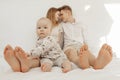 Portrait of young happy couple looking at each other in white clothes with cherubic baby infant toddler sitting on bed.