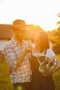 Portrait of young happy farmer couple holding basket with fresh organic vegetables on their rancho at the sunset Royalty Free Stock Photo