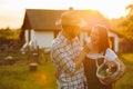 Portrait of young happy farmer couple holding basket with fresh organic vegetables on their rancho at the sunset Royalty Free Stock Photo