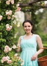 portrait of young woman holding a basket near roses in a garden Royalty Free Stock Photo