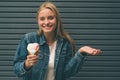 Portrait of young happy girl eating ice-cream, outdoor, over blue wall background. Royalty Free Stock Photo