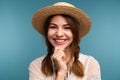 Portrait of a young happy girl in summer hat isolated over blue background Royalty Free Stock Photo