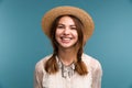 Portrait of a young happy girl in summer hat isolated over blue background, Royalty Free Stock Photo