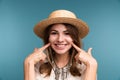 Portrait of a young happy girl in summer hat isolated over blue background Royalty Free Stock Photo