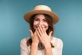 Portrait of a young happy girl in summer hat isolated over blue background, looking at camera, Royalty Free Stock Photo