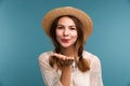 Portrait of a young happy girl in summer hat isolated over blue background, looking at camera Royalty Free Stock Photo