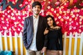 Portrait Of Young happy indian couple in love standing against floral background, boyfriend girlfriend relationship, new year or Royalty Free Stock Photo