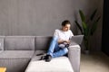 Portrait of young happy man smiling and using laptop while sitting on sofa at home Royalty Free Stock Photo