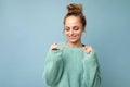 Portrait of young happy positive smiling beautiful blonde woman with sincere emotions wearing casual blue pullover Royalty Free Stock Photo