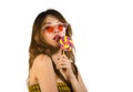 Portrait of young happy and Asian Korean girl in cool fashion sunglasses eating lollipop candy posing naughty teasing Royalty Free Stock Photo