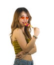 Portrait of young happy and Asian Korean girl in cool fashion sunglasses eating lollipop candy posing naughty teasing Royalty Free Stock Photo