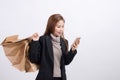 Portrait of young happy smiling Asian woman with shopping bags and smart phone Royalty Free Stock Photo