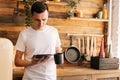 Portrait of young happy smiling man i in casual clothes holding digital tablet and coffee cup Royalty Free Stock Photo