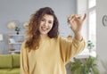 Portrait of a young happy smiling pretty woman with keys in her hands standing at home. Royalty Free Stock Photo